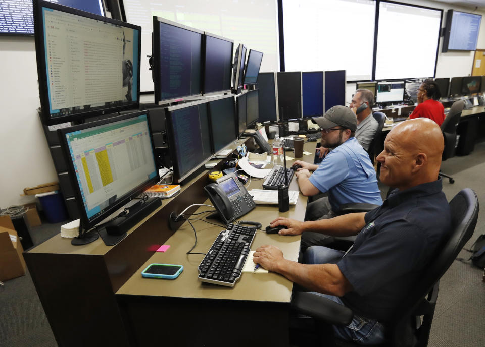 In this Sept. 12, 2019, photo, monitors check their screens in the Governor's Office of Information Technology in Denver. Some cybersecurity professionals are concerned that insurance policies designed to limit the damage of ransomware attacks might actually be encouraging hackers. “We don’t know what that ransom payment is going to fund,” said Brandi Simmons, a spokeswoman for the office. “As a state government, we don’t want to be in a position of funding cyberterrorists.” (AP Photo/David Zalubowski)