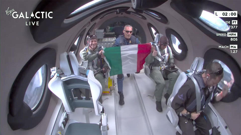 Italian Air Force Col. Walter Villadei unfurls an Italian flag as he and the crew enjoy a few minutes of weightlessness. / Credit: Virgin Galactic