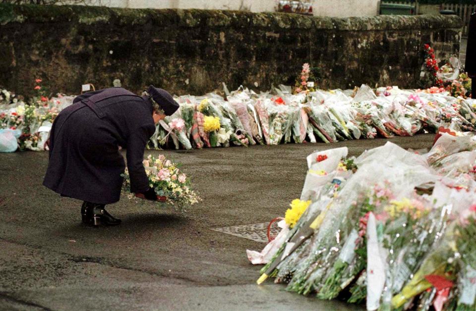 Queen Elizabeth the second lays flowers at Dunblane Primary School after a shooting there, on March 17, 1996