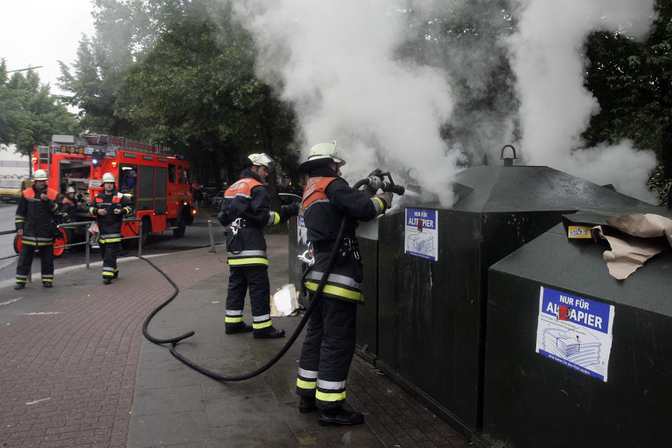 FILE - In this May 28, 2007, file photo fire fighters extinguish a burning waste container during clashes with protestors during a demonstration in Hamburg, Germany. Thousands of people demonstrated against the ASEM meeting and the upcoming G-8 summit in Heiligendamm at the Baltic Sea. The G-7 is an informal club of rich democracies that aim to enhance their friendship and synchronize their views. The initial group was six, with Canada added in 1976. Russia joined in 1998 but was suspended over its occupation of Ukraine's Crimean Peninsula in 2014. (AP Photo/Patrick Lux, File)