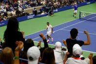 Fans celebrate after Roger Federer of Switzerland (in white) won a point against Novak Djokovic of Serbia in their men's singles final match at the U.S. Open Championships tennis tournament in New York, September 13, 2015. REUTERS/Lucas Jackson