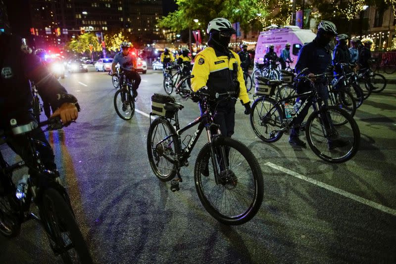 Police officers with bicycles walk as people gather after a rally demanding a fair count of the votes of the 2020 U.S. presidential election, in Philadelphia