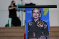 A musician plays a violin behind a photograph of cinematographer Halyna Hutchins during a vigil in her honor in Albuquerque, N.M., Saturday, Oct. 23, 2021. Hutchins was fatally shot on Thursday, Oct. 21, after an assistant director unwittingly handed actor Alec Baldwin a loaded weapon and told him it was safe to use on the set of a Western filmed in Santa Fe, N.M. (AP Photo/Andres Leighton)