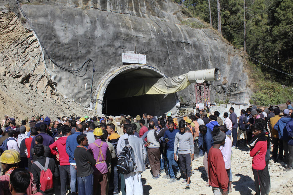 People watch rescue and relief operations at the site of an under-construction road tunnel that collapsed in mountainous Uttarakhand state, India, Wednesday, Nov. 15, 2023. Rescuers have been trying to drill wide pipes through excavated rubble to create a passage to free 40 construction workers trapped since Sunday. A landslide Sunday caused a portion of the 4.5-kilometer (2.7-mile) tunnel to collapse about 200 meters (500 feet) from the entrance. It is a hilly tract of land, prone to landslide and subsidence. (AP Photo)