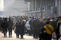 People wearing face masks to protect against the spread of the coronavirus line up for mass COVID-19 testing in a central district of Beijing, Friday, Jan. 22, 2021. Beijing has ordered fresh rounds of coronavirus testing for about 2 million people in the downtown area following new cases in the Chinese capital. (AP Photo/Mark Schiefelbein)