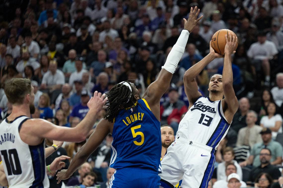 Sacramento Kings forward Keegan Murray (13) shoots a basket over Golden State Warriors forward Kevon Looney (5) during an NBA play-in game at Golden 1 Center on Tuesday, April 16, 2024.