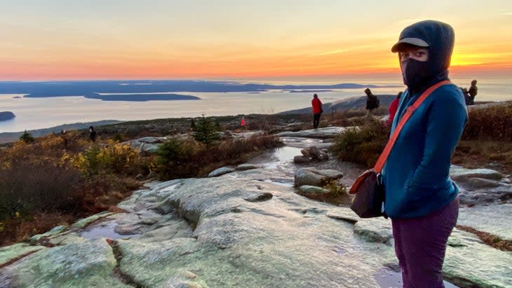 <span class="article__caption">The author takes in sunrise atop Cadillac Mountain.</span> (Photo: Emily Pennington)