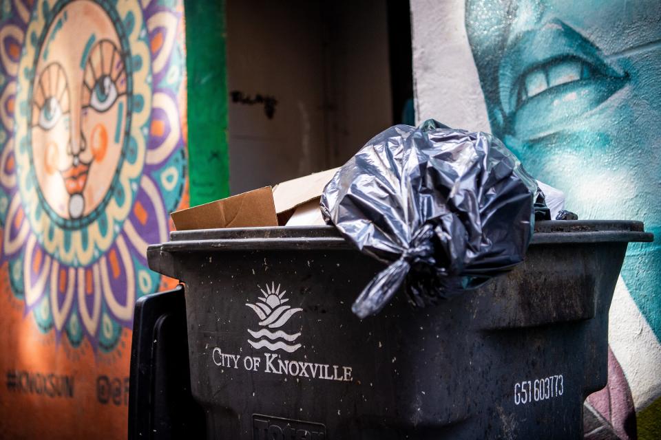 Trash bags fill a rolling can in Strong Alley near Market Square in downtown Knoxville.
