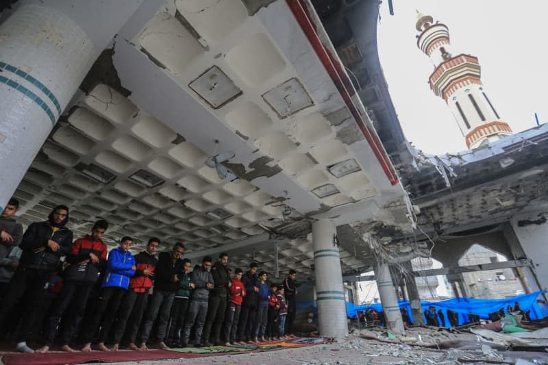 Palestinians perform Friday prayers on the ruins of Al-Huda Mosque, which was destroyed by Israeli raids in Rafah in the southern Gaza Strip. Mohammed Talatene/dpa