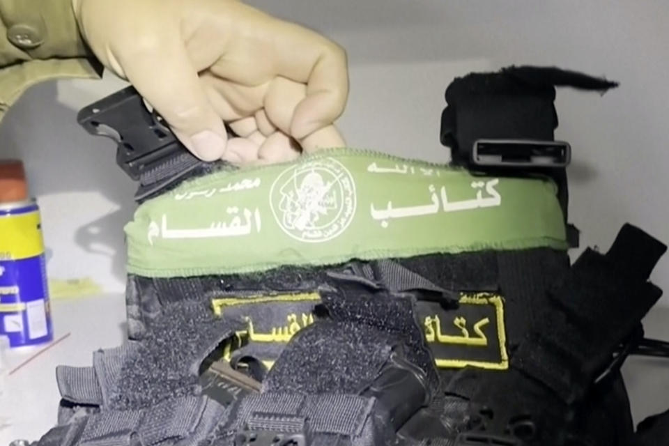 In this image taken from a video released by the Israeli Defense Forces, Wednesday, Nov. 15, 2023, Lt. Col. Jonathan Conricus, an Israeli military spokesman, holds up a bullet proof vest with a Hamas insignia that was found along with weapons the IDF says were found in a medical closet at the MRI center at al-Shifa hospital in Gaza City. (Israel Defense Forces via AP)