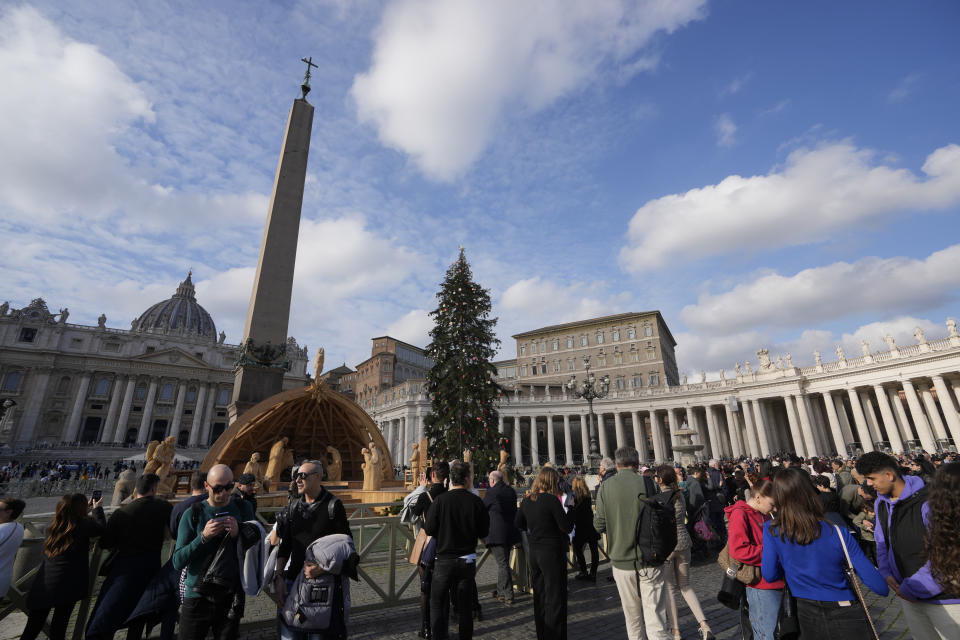 People pause in front of St' Peter's Basilica at The Vatican, Saturday, Dec. 31, 2022. Pope Emeritus Benedict XVI, the German theologian who will be remembered as the first pope in 600 years to resign, has died, the Vatican announced Saturday. He was 95. (AP Photo/Andrew Medichini)