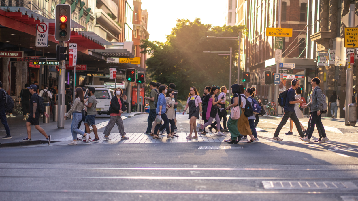 Workers cross of busy street in the Sydney CBD.