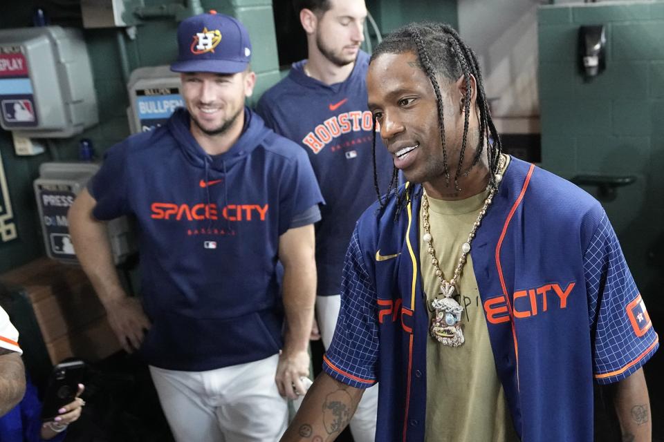 FILE - Houston rapper Travis Scott, right, is joined by Houston Astros Alex Bergman, left, and Kyle Tucker, as he waits to hit before a baseball game between the Chicago Cubs and Houston Astros Monday, May 15, 2023, in Houston. Houston Astros slugger Kyle Tucker and rap superstar Travis Scott, are featured on one of two “Signature Tunes” cards that are part of the latest edition of Topps Series 2, shining a light on players and the artists behind their walk-up music. (AP Photo/David J. Phillip, File)