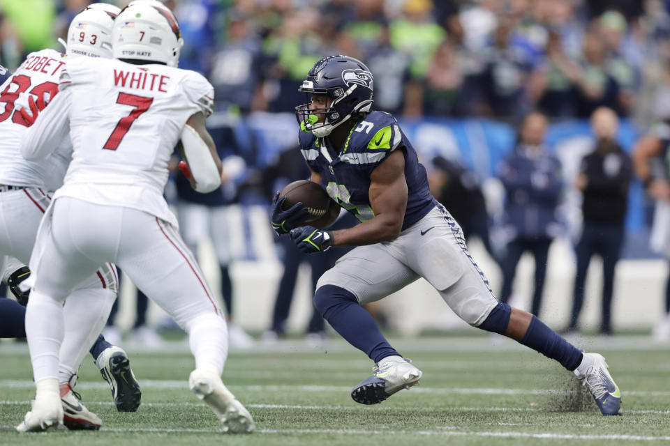 Seattle Seahawks running back Kenneth Walker III (9) looks for running room as Arizona Cardinals linebacker Kyzir White (7) and Cardinals defensive end Jonathan Ledbetter, left, close in during the second half of an NFL football game Sunday, Oct. 22, 2023, in Seattle. The Seahawks won 20-10. (AP Photo/John Froschauer)