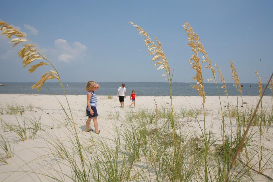 A family walks on the beach in Bay St. Louis, Miss
