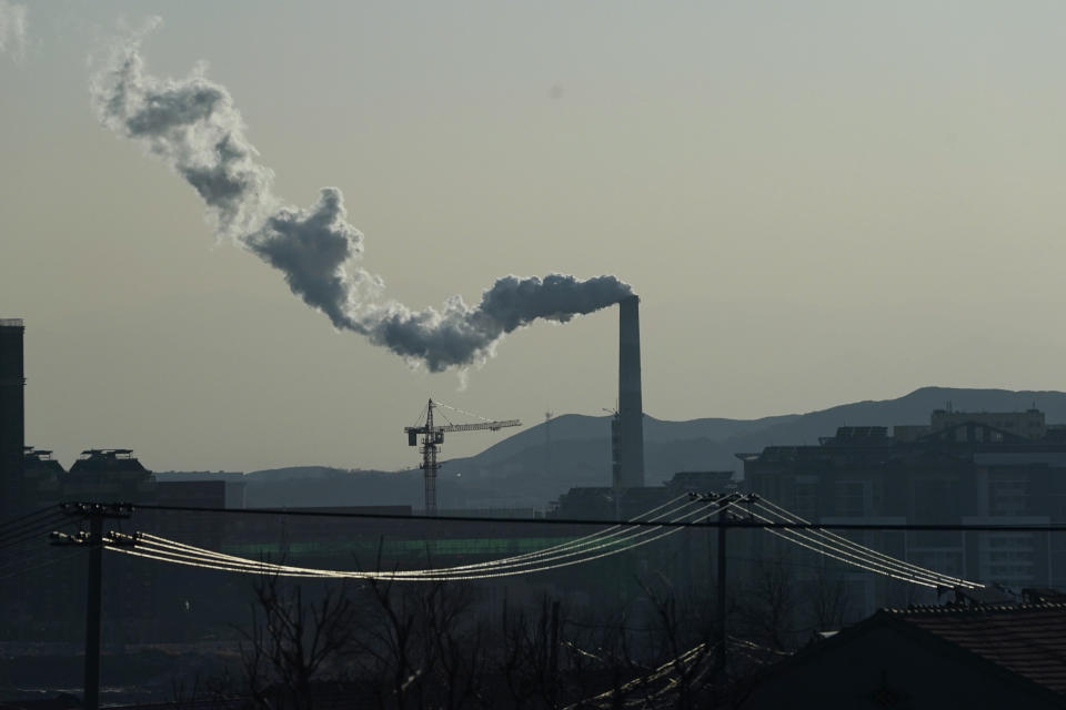 Smoke comes out of a chimney near cables from a high speed train traveling from Beijing to neighboring Zhangjiakou in northwestern China's Hebei province on Dec. 15, 2020. Expectations are high that the 14th five-year plan will align domestic policies with international pledges on climate change. Chinese President Xi Jinping made a surprise pledge at a United Nations meeting in September that China would go carbon neutral by 2060. (AP Photo/Ng Han Guan)