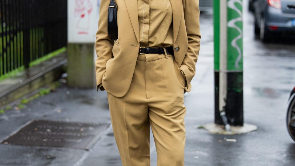 Sarah Lysander wears beige blazer, pants, button shirt, black bag, head band outside Tods during the Milan Fashion Week