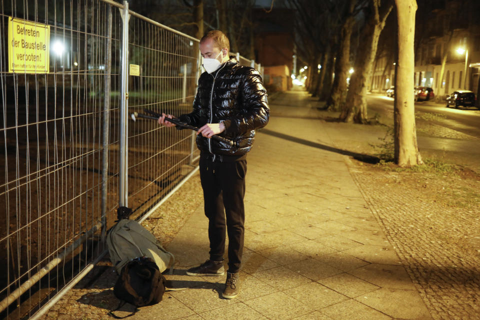 Brazilian activist and artist Rafael Puetter prepares himself prior to his one-man protest through Berlin, Germany, late Tuesday, April 6, 2021. The multimedia artist starts his performance, dressed as the grim reaper, at the Brazilian embassy in Berlin at midnight every night to protest against Brazil's COVID-19 policies. Rafael Puetter walks to the Brandenburg Gate and then to the nearby German parliament building, in front of which he counts out a sunflower seed to represent each of the lives that were lost over the past 24 hours in Brazil because of the coronavirus pandemic. (AP Photo/Markus Schreiber)