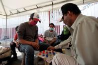 A Honduran migrant, who left his country after the damage left by Hurricanes Eta and Iota, plays with other migrants at a migrant shelter in Guadalupe