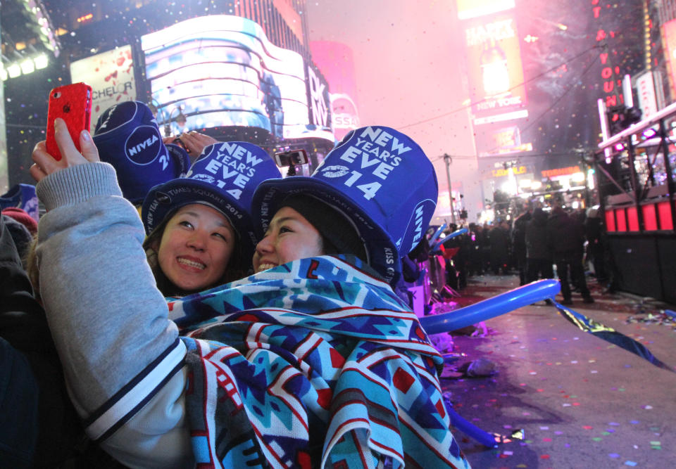 Revelers take part in the festivities in New York's Times Square shortly after midnight New Year's Day Wednesday Jan. 1, 2014. (AP Photo/Tina Fineberg)