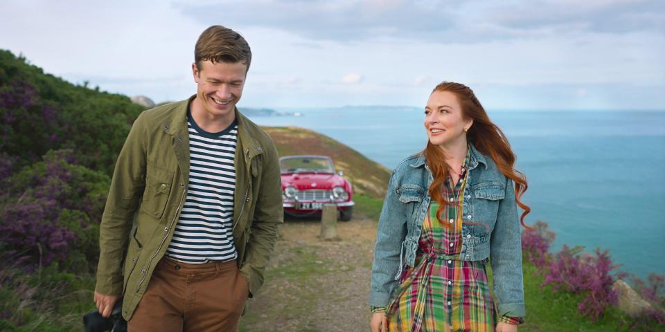Ed Speleers and a red-haired Lindsay Lohan side by side on an Ireland hilltop.