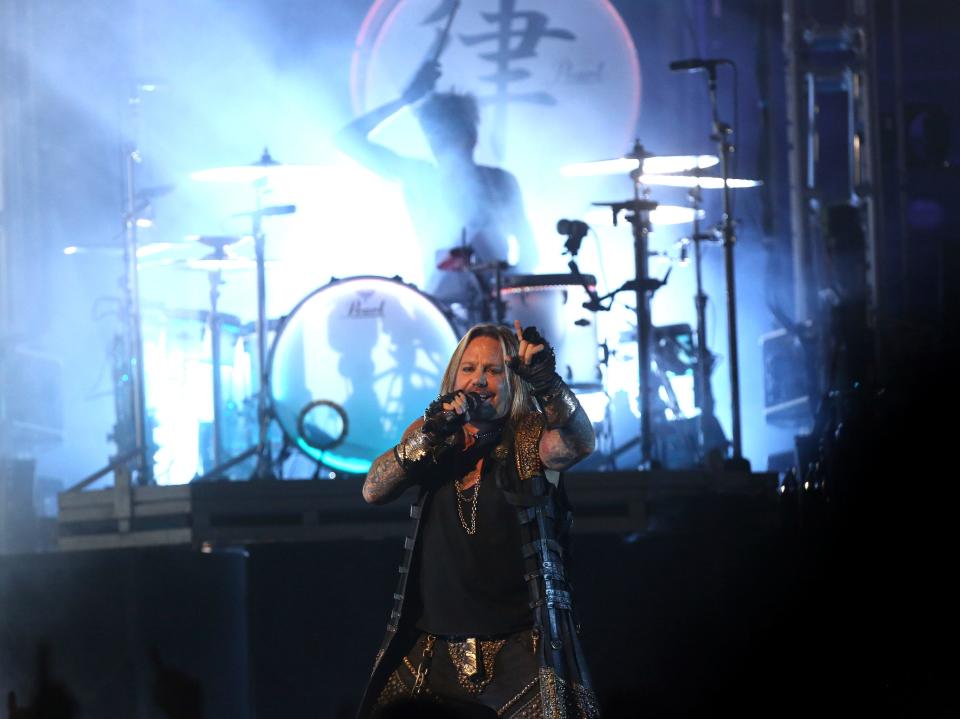 Frontman Vince Neil performs with Motley Crue at the KFC Yum! Center in Louisville. In the background is drummer Tommy Lee.This is their final tour as a band. Oct. 14, 2014.