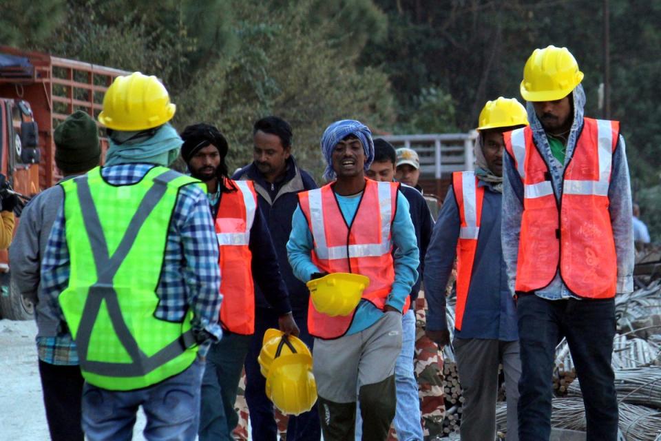 Rescuers walk near the site of an under-construction road tunnel that collapsed in mountainous Uttarakhand state.