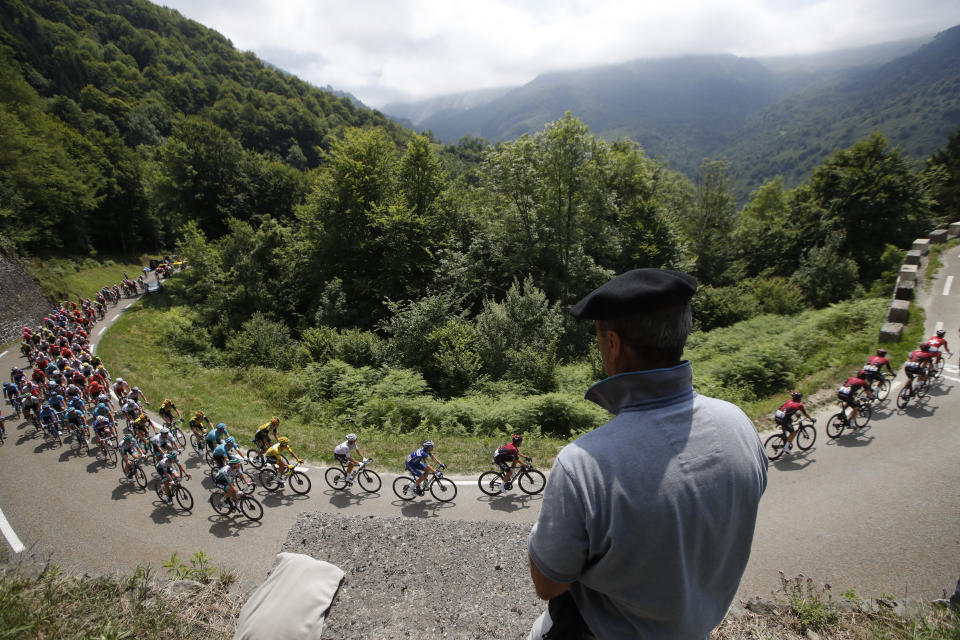 A spectator watches the pack as he rides during the fourteenth stage of the Tour de France cycling race over 117,5 kilometers (73 miles) with start in Tarbes and finish at the Tourmalet pass, France, Saturday, July 20, 2019. (AP Photo/ Christophe Ena)