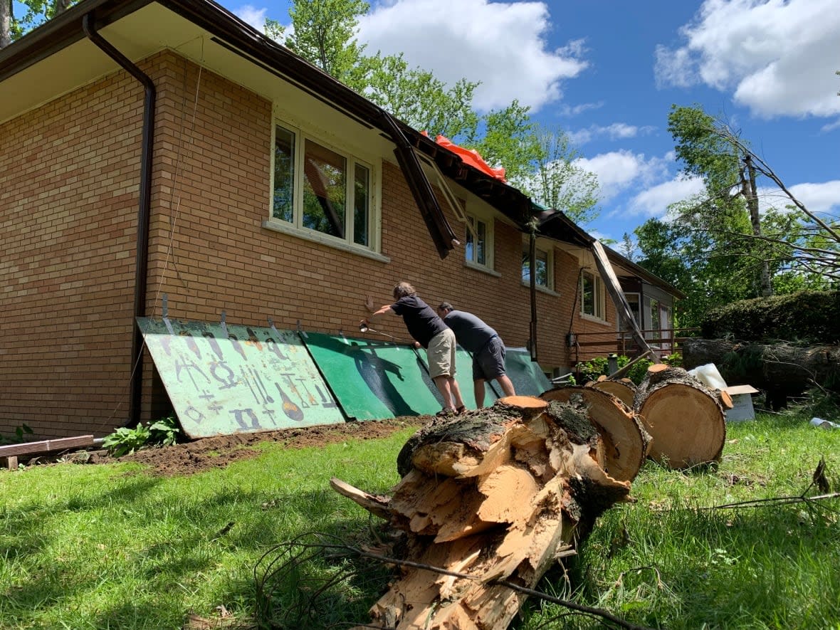 Residents in Ottawa's Nepean neighbourhood continue cleaning up debris a week after a major derecho storm swept through the area. (Rebecca Kwan/CBC - image credit)