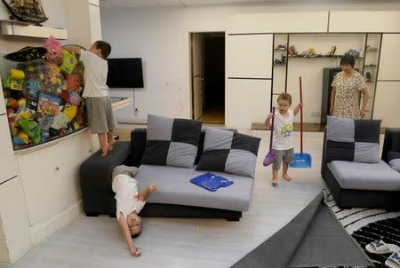 An Hui's and Ye Jianbin's sons An Zhifei, An Zhizhong and An Zhiya, play next to their grandmother at home in Shenzhen, Guangdong province, China September 18, 2018. The triplets were conceived with the help of a German egg donor. REUTERS/Jason Lee