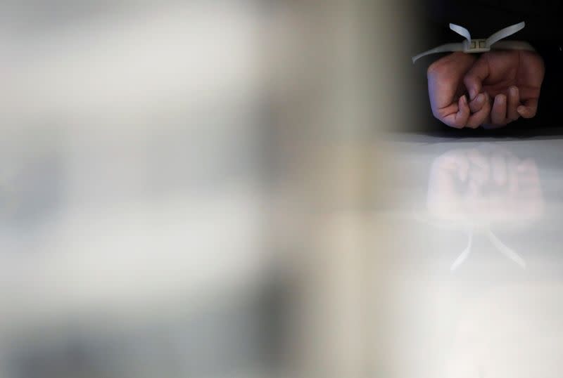 Hands of an anti-government protester are pictured while being detained inside the Sheung Shui shopping mall in Hong Kong