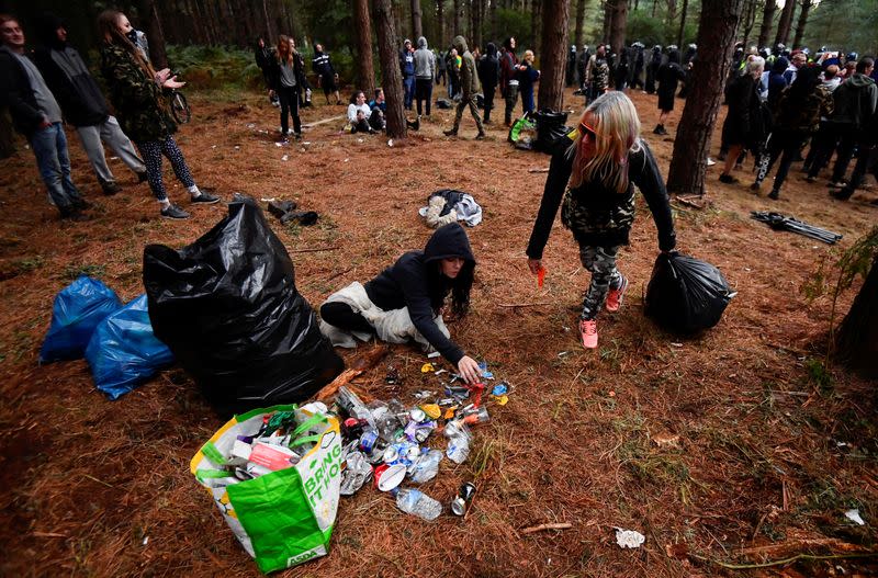 Revellers tidy up rubbish after a suspected illegal rave in Thetford Forest