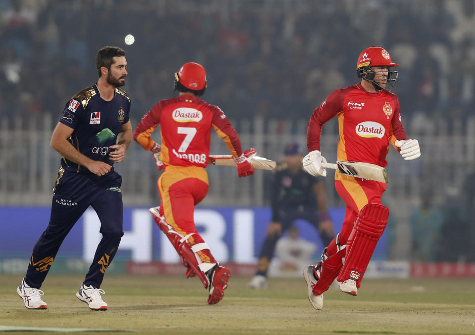 Islamabad United batsmen Colin Ingram, right, and Shadab Khan, center, take a run while Quetta Gladiators pacer Ben Cutting watches during their Pakistan Super League T20 cricket match at Rawalpindi stadium in Rawalpindi, Pakistan, Thursday, Feb. 27, 2020. (AP Photo/Anjum Naveed)