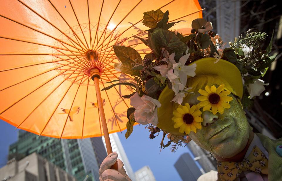 A participant dressed in costume holds an umbrella at the annual Easter Bonnet Parade in New York