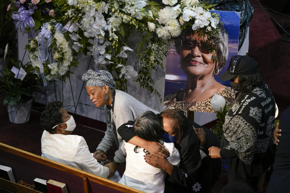 Mourners comfort Angela Crawley, seated at bottom left, and Robin Harris, daughters of Ruth Whitfield, a victim of the Buffalo supermarket shooting, before a memorial service at Mt. Olive Baptist Church with Vice President Kamala Harris in attendance, Saturday, May 28, 2022, in Buffalo, N.Y. (AP Photo/Patrick Semansky)