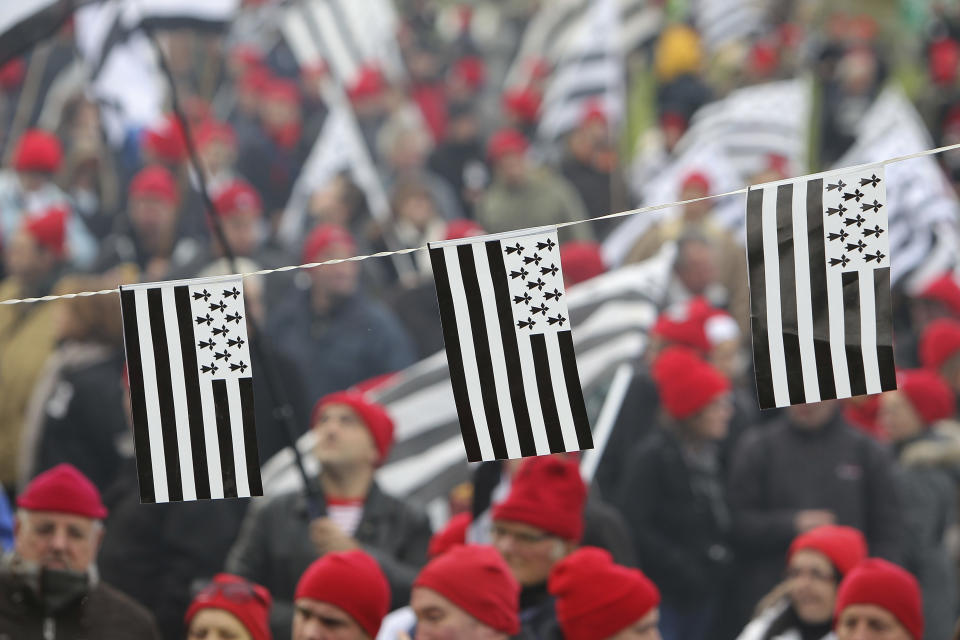 REMOVES THE REFERENCE TO THE NUMBER OF YEARS OF THE ADMINISTRATIVE REGIONS FILE - In this Nov.30, 2013 file photo, protesters wearing red hats and flags of Brittany take part a demonstration against job losses and against the government’s “eco-tax”, a controversial environmental tax on heavy good Is vehicles, in Carhaix, Brittany. France’s administrative regions have been part of the identity of citizens of the sprawling and diverse country. Now, merging some of them is seen as a logical way to save money on bureaucracy, and the French support it _ as long as it’s someone else’s region. (AP Photo/David Vincent, FILE)