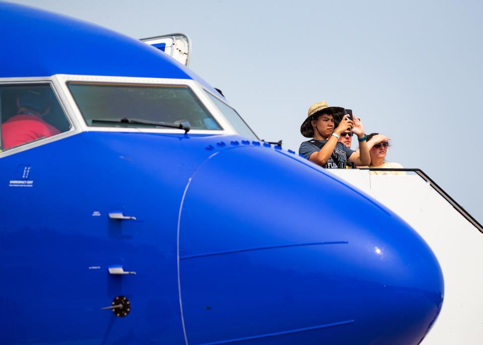 Attendees look out from the top of a staircase before touring a Southwest Airlines plane in Boeing Plaza during EAA AirVenture Oshkosh 2023 on Monday, July 24, 2023, in Oshkosh, Wis. Seeger Gray/USA TODAY NETWORK-Wisconsin