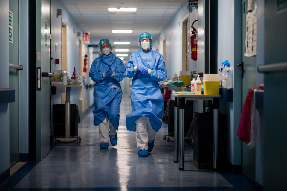 Nurses in protective gear walk down the hall at a hospital in Cremona, Italy. (Photo by Marco Mantovani/Getty Images)
