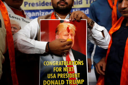 A member of Hindu Sena, a right-wing Hindu group, holds a poster of U.S. Republican presidential nominee Donald Trump as they symbolically celebrate his victory in the upcoming U.S. elections, in New Delhi, India, November 4, 2016. REUTERS/Adnan Abidi