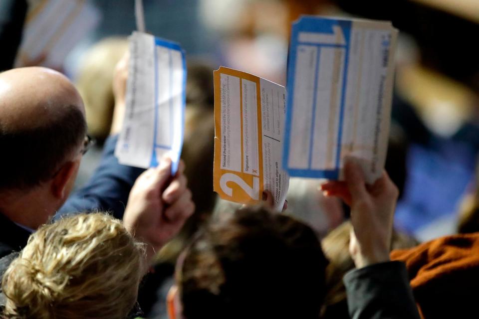 PHOTO: In this Feb. 3, 2020, file photo, caucus goers hold up their first votes as they are counted at the Knapp Center on the Drake University campus in Des Moines, Iowa. (Gene J. Puskar/AP, FILE)