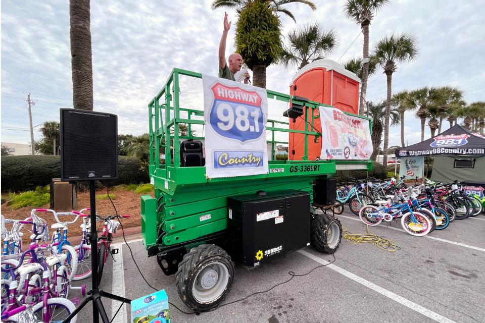 Highway 98 Country radio host Scott Mallory celebrates the conclusion of the station's 2021 Bikes or Bust Christmas bicycle and toy drive Monday at Uptown Station in Fort Walton Beach. Mallory had spent the previous 98 hours living atop a small scissor lift to promote the four-day event.