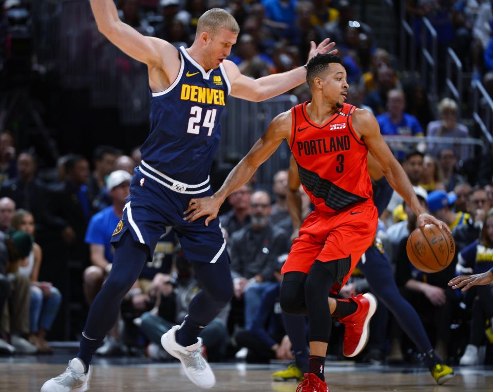 Portland Trail Blazers guard CJ McCollum, right, drives past Denver Nuggets forward Mason Plumlee in the first half of Game 7 of an NBA basketball second-round playoff series Sunday, May 12, 2019, in Denver. (AP Photo/John Leyba)