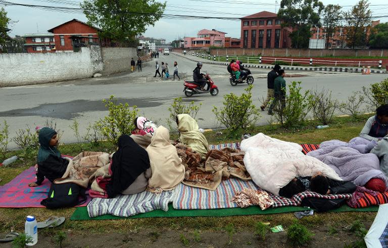 A family rest next to a road in Kathmandu