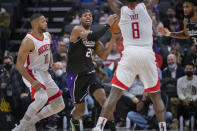 Sacramento Kings guard Buddy Hield (24) is guarded by Houston Rockets guard Eric Gordon (10) and forward Jae'Sean Tate (8) during the second half of an NBA basketball game in Sacramento, Calif., Friday, Jan. 14, 2022. The Kings won 126-114. (AP Photo/Randall Benton)