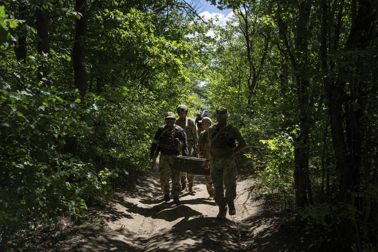 Ukrainian servicemen carry ammunition during training in Kharkiv region, Ukraine, Tuesday, July 19, 2022. (AP Photo/Evgeniy Maloletka)