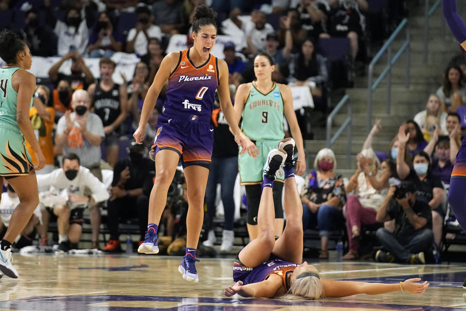 Phoenix Mercury guard Kia Nurse (0) celebrates with guard Sophie Cunningham (9) in front of New York Liberty guard Rebecca Allen (9) during the second half in the first round of the WNBA basketball playoffs, Thursday, Sept. 23, 2021, in Phoenix. Phoenix won 83-82. (AP Photo/Rick Scuteri)