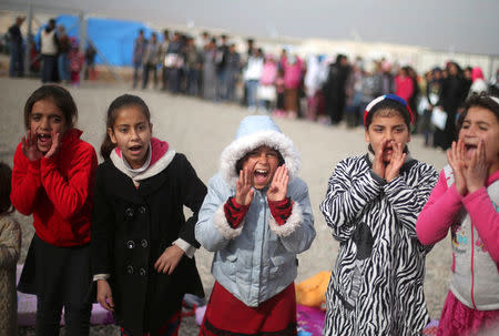 Displaced Iraqi girls sing outside tent schools set by United Nations Children's Fund (UNICEF) at Hassan Sham camp, east of Mosul, Iraq December 8, 2016. REUTERS/Mohammed Salem