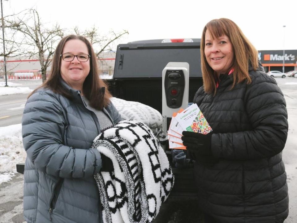 Jimi Meier, left, and Hallie Jacobs are Abbotsford dairy farmers collecting gift card donations to support other families that lost clothing and household items during November&#39;s floods.  (Baneet Braich/CBC - image credit)