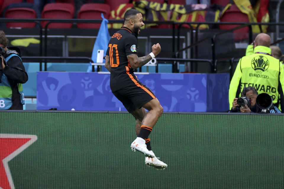 Memphis Depay of the Netherlands celebrates after scoring his side's opening goal during the Euro 2020 soccer championship group F match between North Macedonia and Netherlands, at the Johan Cruyff ArenA in Amsterdam, Netherlands, Monday, June 21 2021. (Kenzo Tribouillard/Pool via AP)