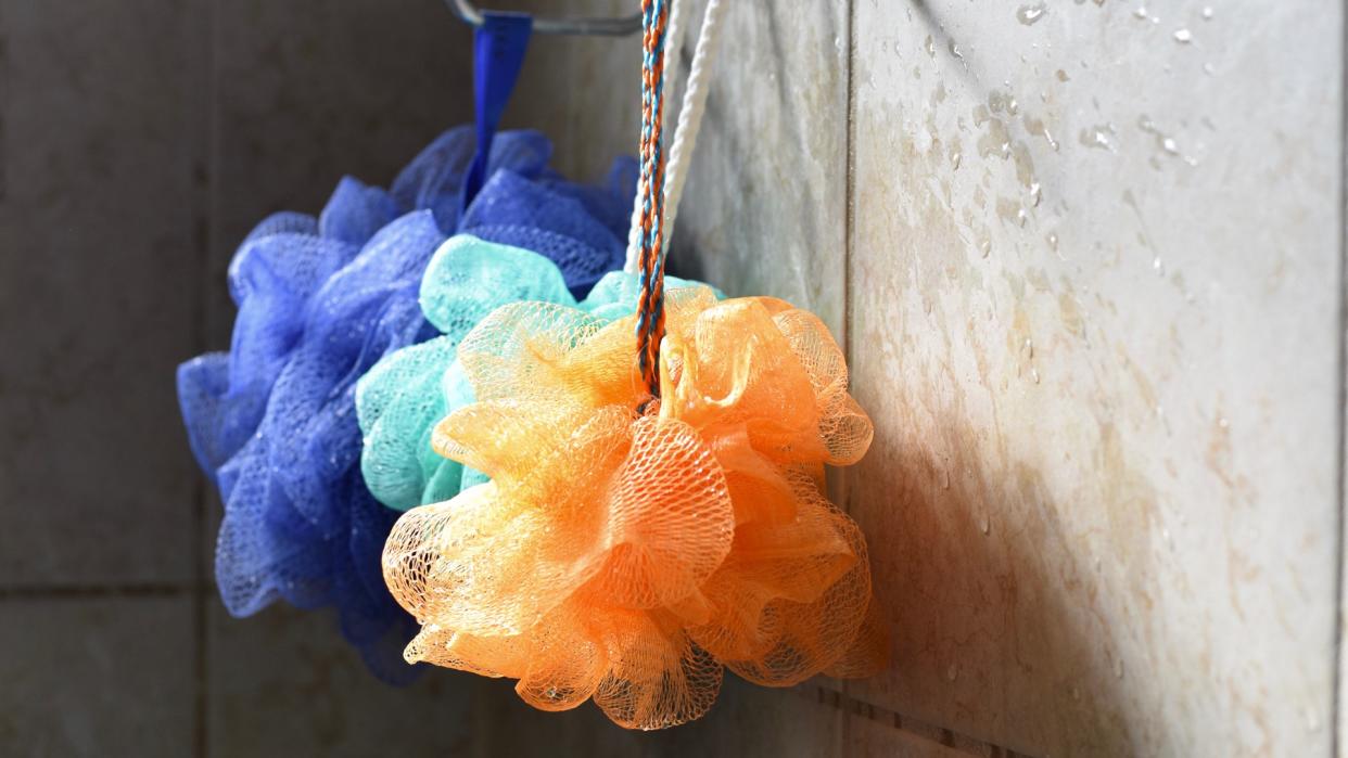 Light catches loofahs hanging from a rack.